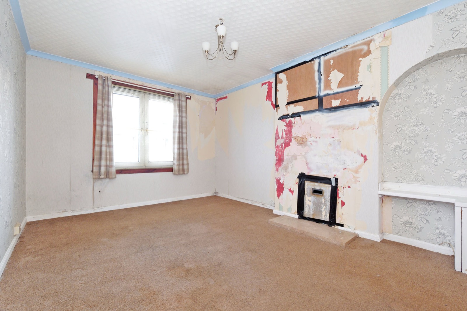 Living room with peeling wallpaper before refurbishment